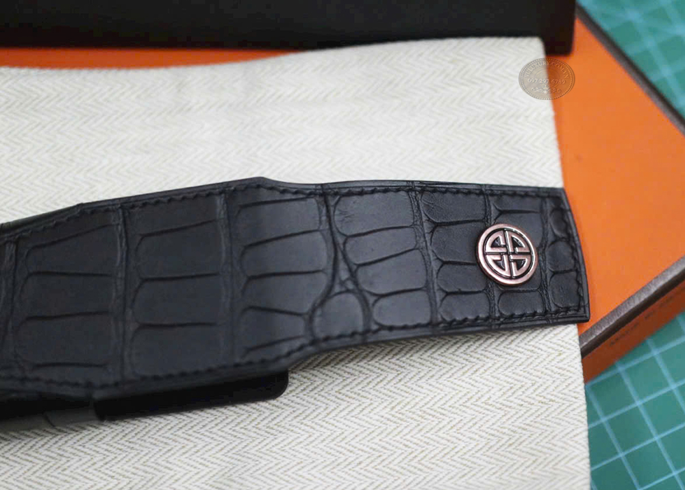 Huy hiệu XOR màu vàng hồng lấp lánh trên bao da cá sấu đen Huy hiệu XOR màu vàng hồng lấp lánh trên bao da cá sấu đen